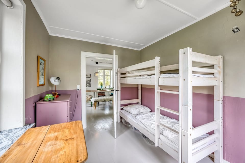 The children's room with white bunk beds against olive and mauve walls.